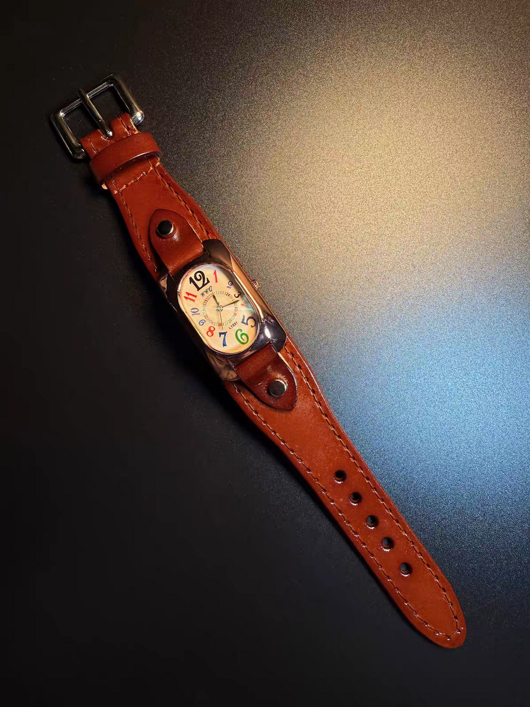 Vintage multicolor numeral leather cuff watch with brown strap and elongated tonneau case