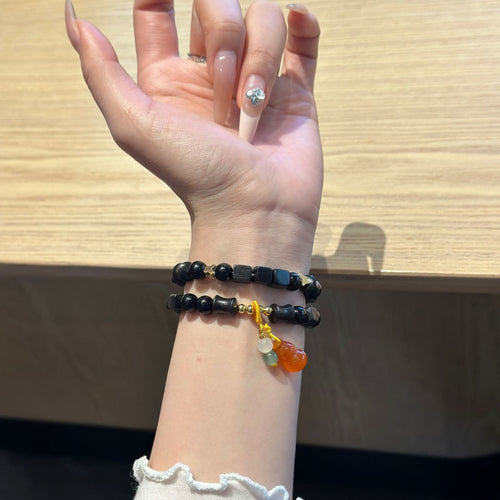 Black beaded amber charm Apple Watch bracelet band worn on wrist