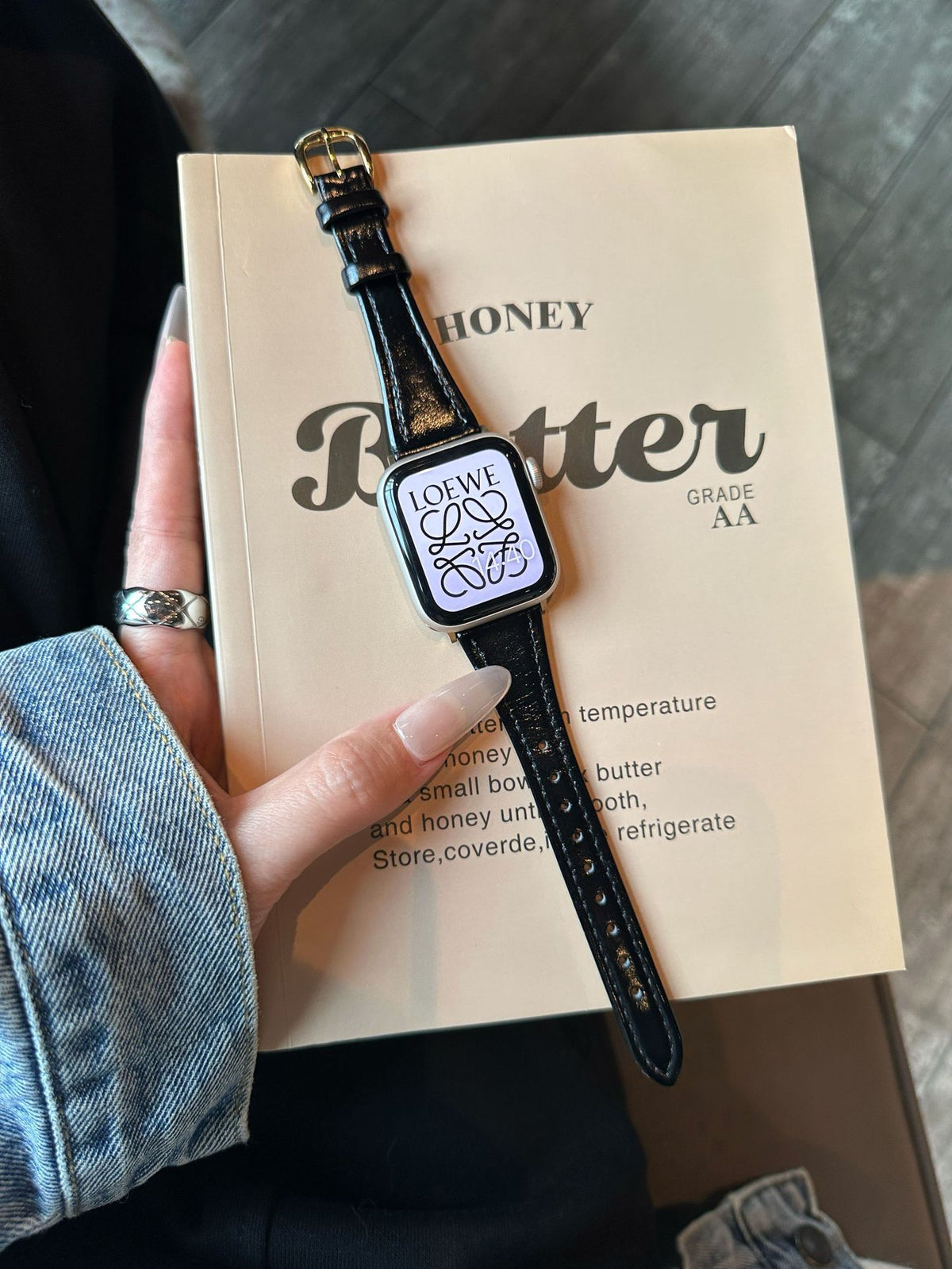 Black leather Apple Watch band with gold-tone buckle