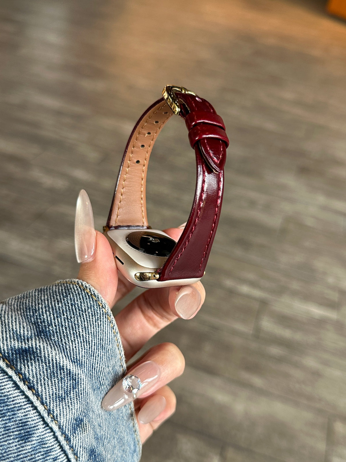 Burgundy leather Apple Watch band with gold-tone buckle