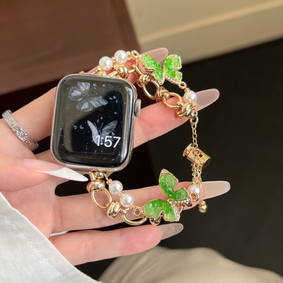 Aurora green butterfly loop-chain gold Apple Watch bracelet band in hand