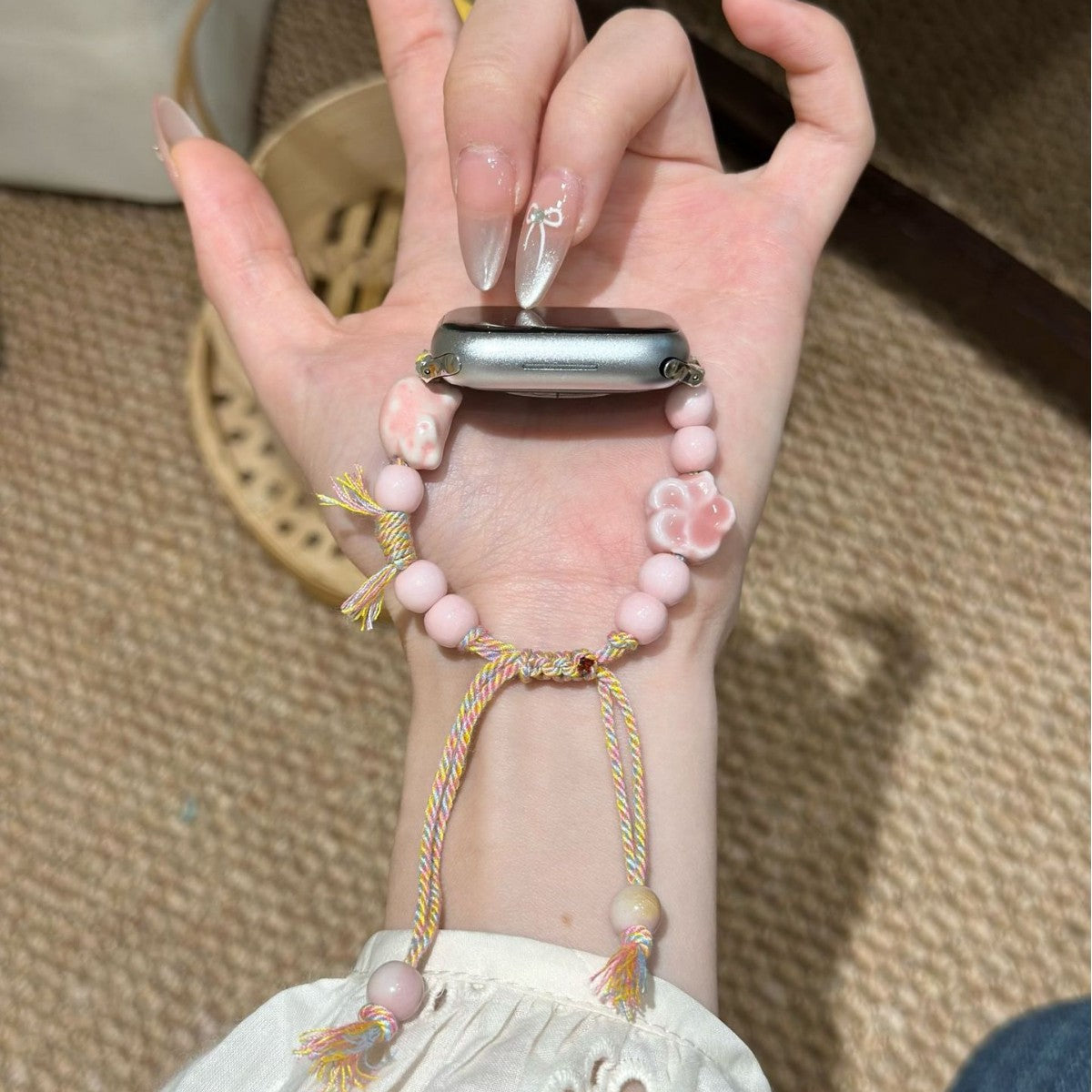 Blush pink beaded Apple Watch band with floral charm and tassel cord