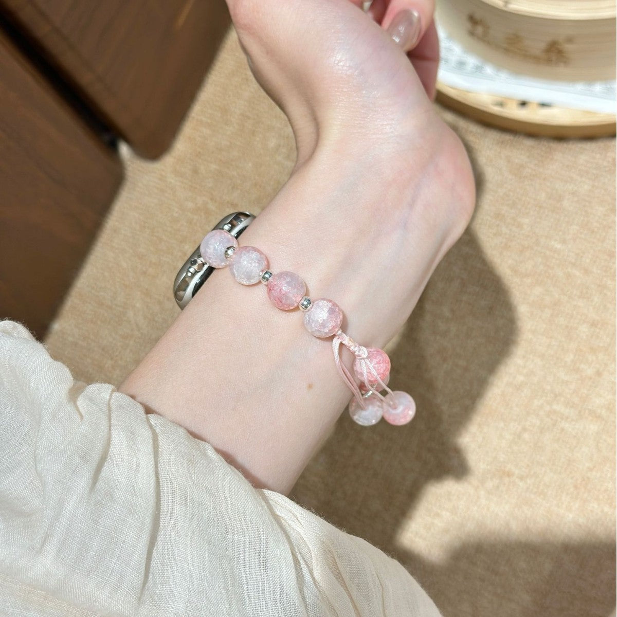 Pink beaded butterfly charm Apple Watch bracelet band worn on wrist
