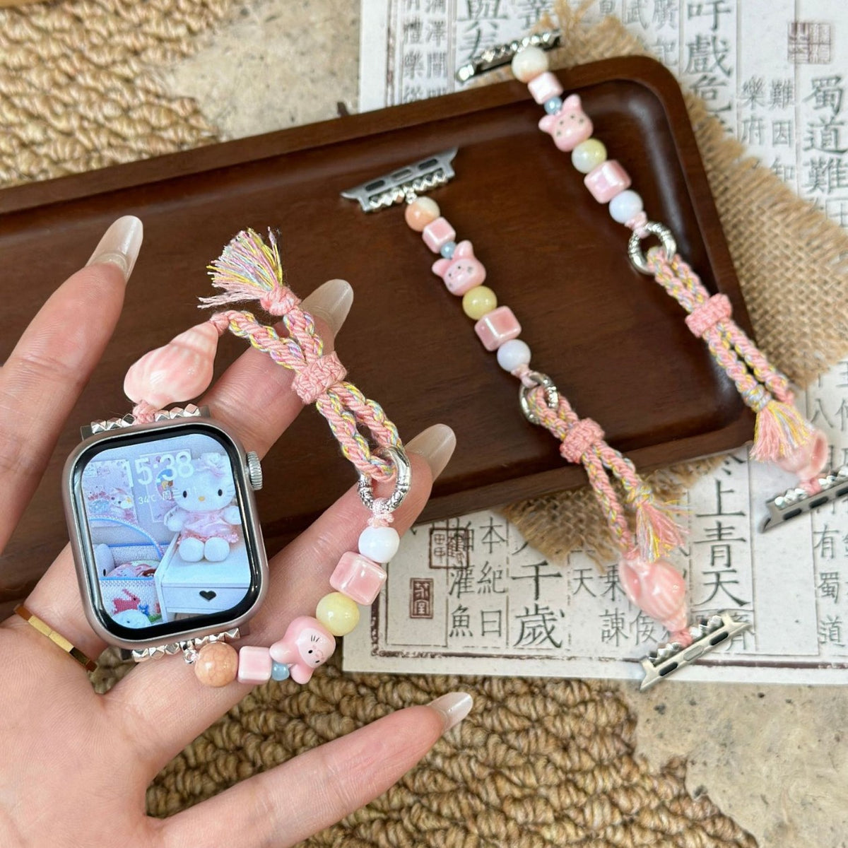 Pink braided and beaded jewellery Apple Watch band with small cat charm