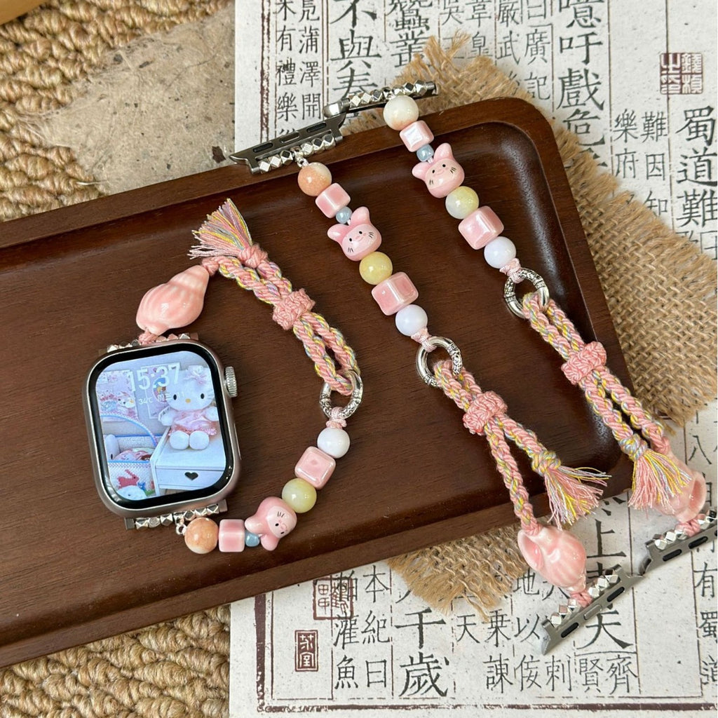 Pink braided beaded Apple Watch band styled beside matching strap