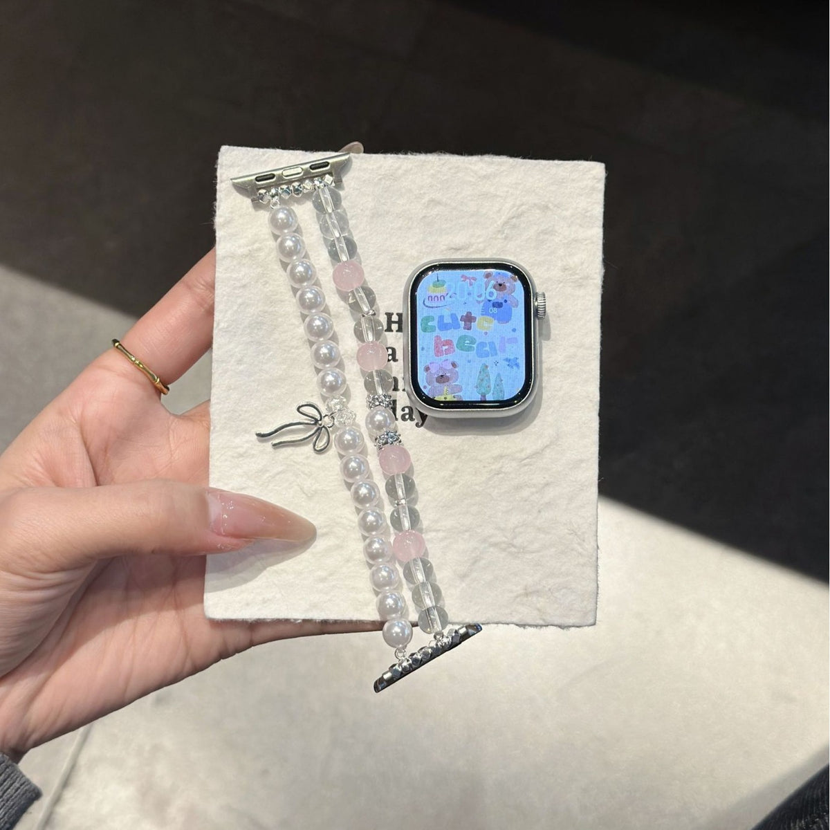 Blush pink pearl bow Apple Watch bracelet band laid flat