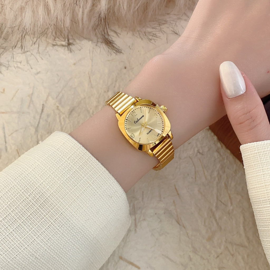 CABOSEN vintage small women's watch with polished gold-tone stretch bracelet and champagne dial on wrist