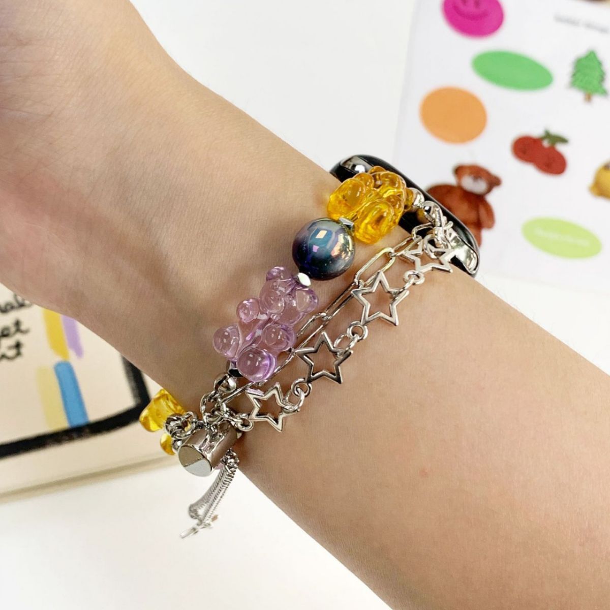 Yellow and pastel candy bear Apple Watch charm band worn on wrist