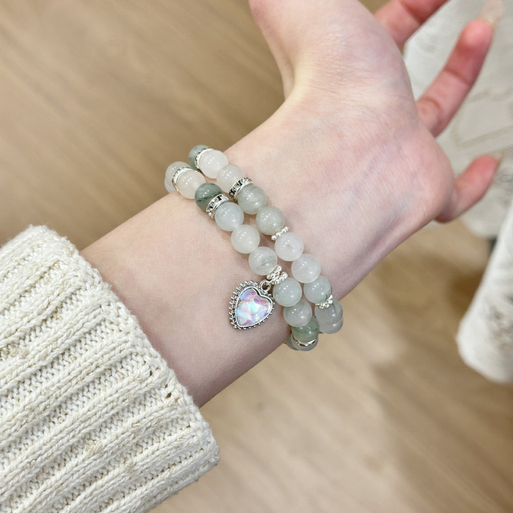 White and pale green double-strand Apple Watch bracelet band worn on wrist