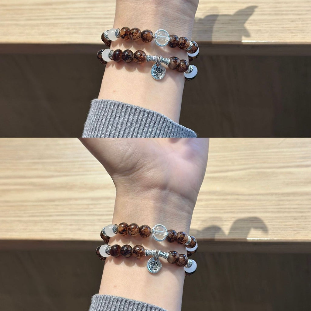 Cocoa brown and clear double-strand Apple Watch band worn on wrist