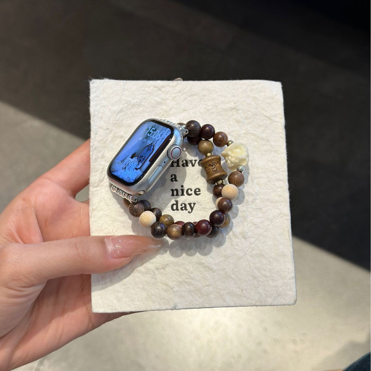 Brown rose double-strand Apple Watch bracelet band displayed on textured card