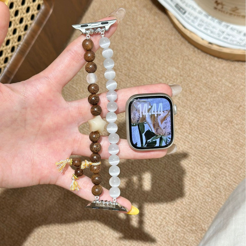 Brown and milky white double-strand Apple Watch bracelet band held in hand