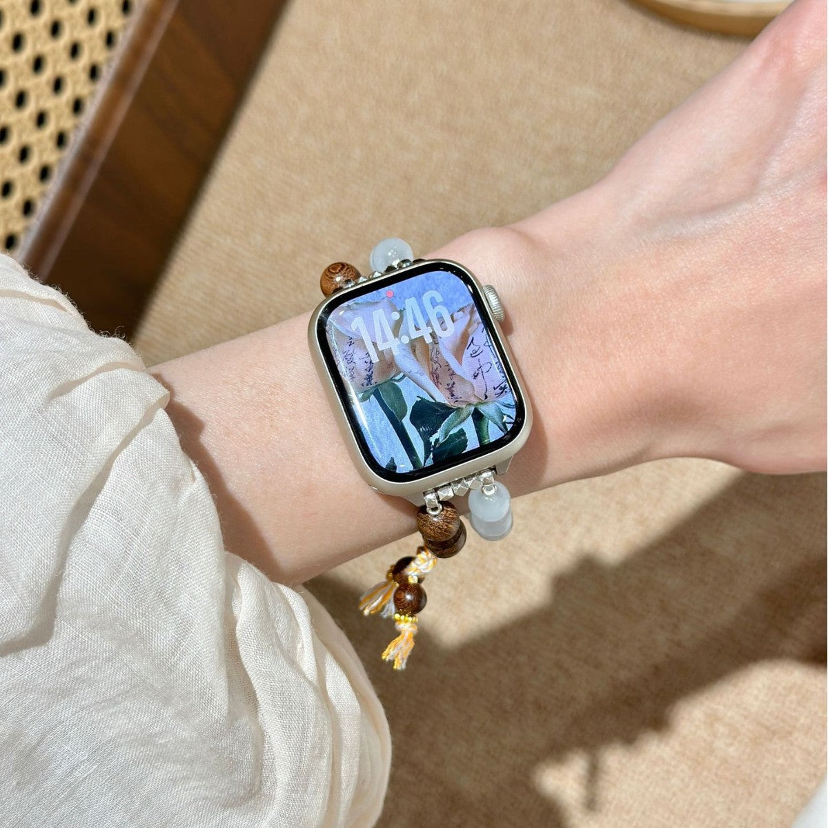 Brown and milky white double-strand Apple Watch bracelet band worn on wrist