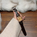 Vintage crystal tonneau women's watch with black leather strap and champagne dial