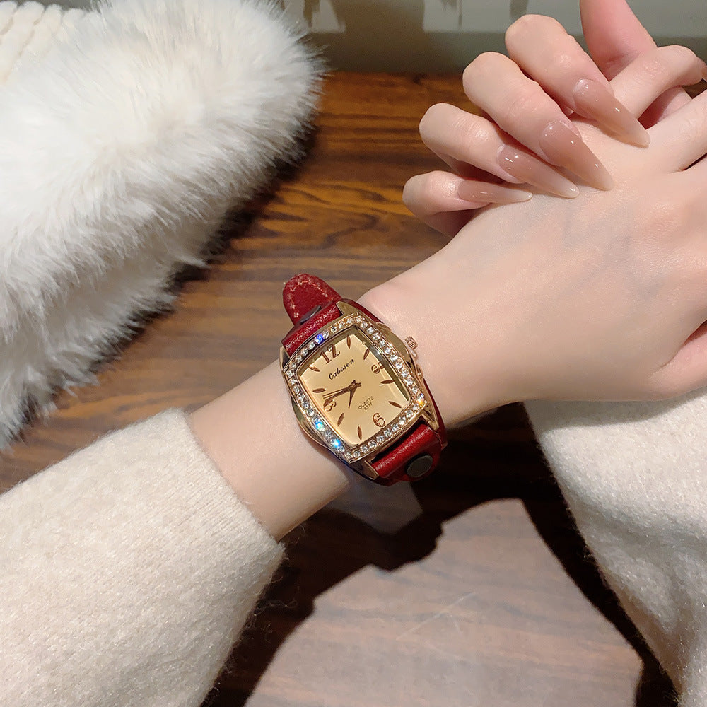 Vintage crystal tonneau women's watch with burgundy leather strap and champagne dial on wrist