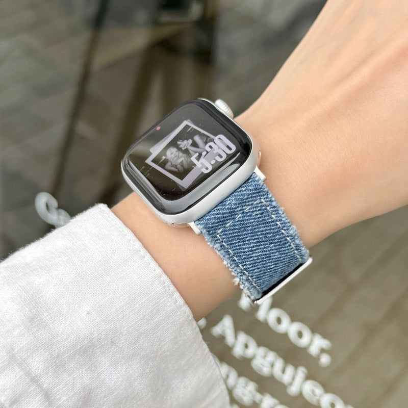 Blue denim Apple Watch band worn on wrist