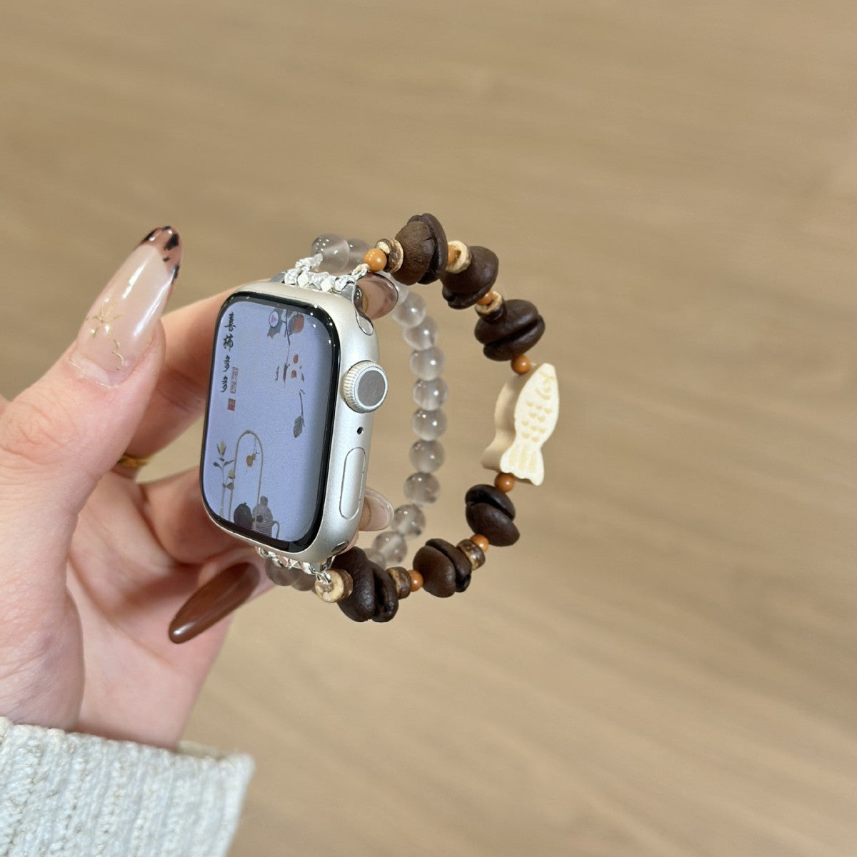Brown wood and smoky bead fish charm Apple Watch bracelet band worn on wrist