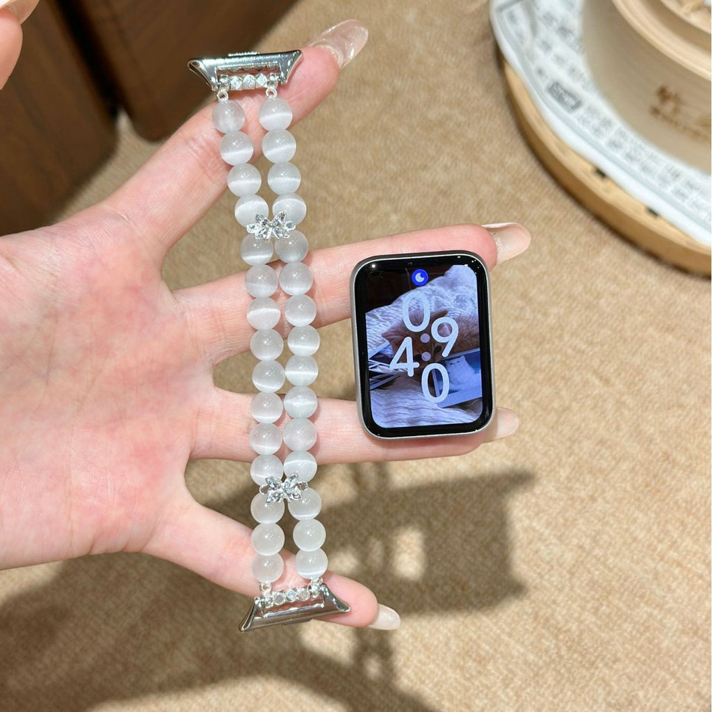 Frosted white double-strand Apple Watch bracelet band held in hand