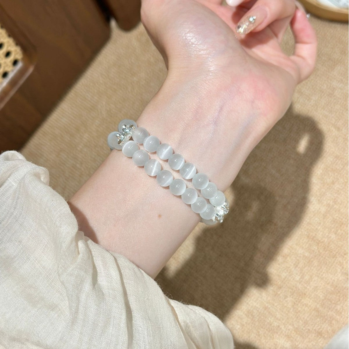 Frosted white double-strand Apple Watch bracelet band worn on wrist