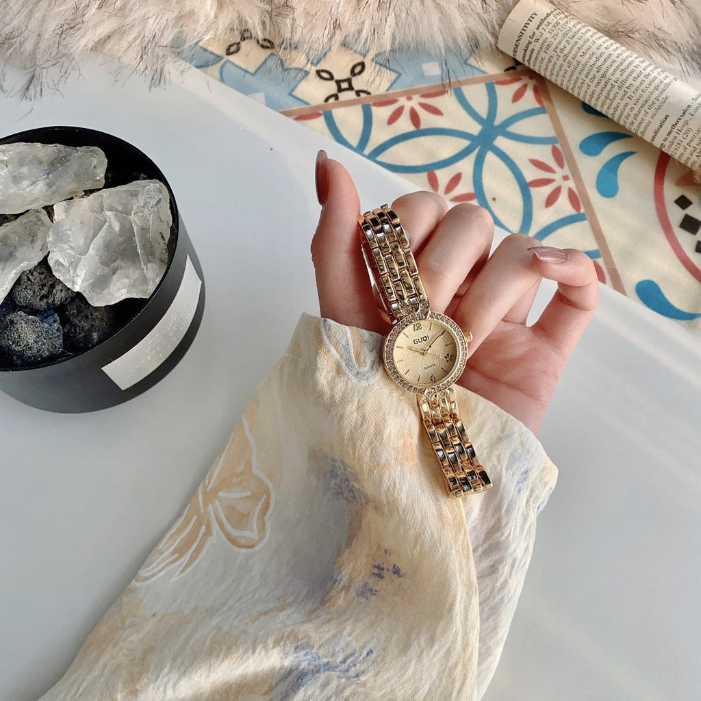 GUDI crystal-style bezel round bracelet watch in gold tone with champagne dial