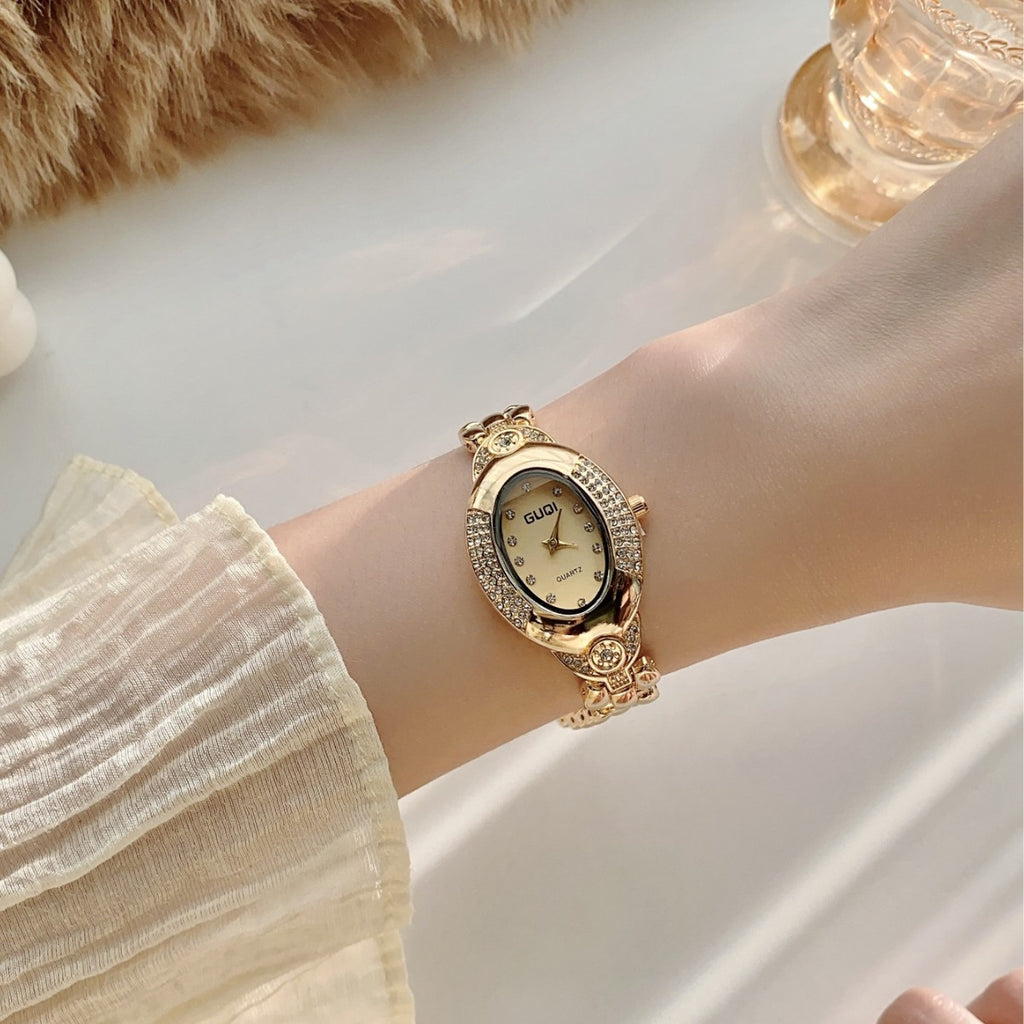 GUDI oval crystal-style jewelry watch with sculpted link bracelet and champagne dial on wrist