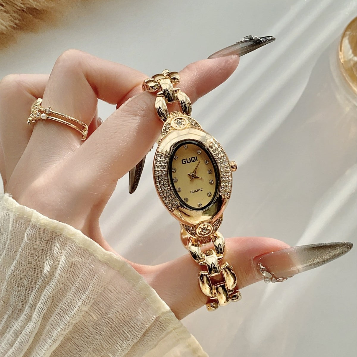 GUDI oval crystal-style jewelry watch with sculpted link bracelet and champagne dial