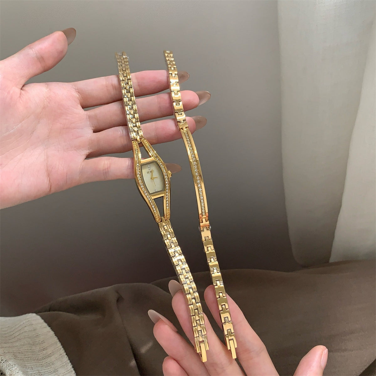 IEKE gold-tone women's crystal bracelet watch held in hand