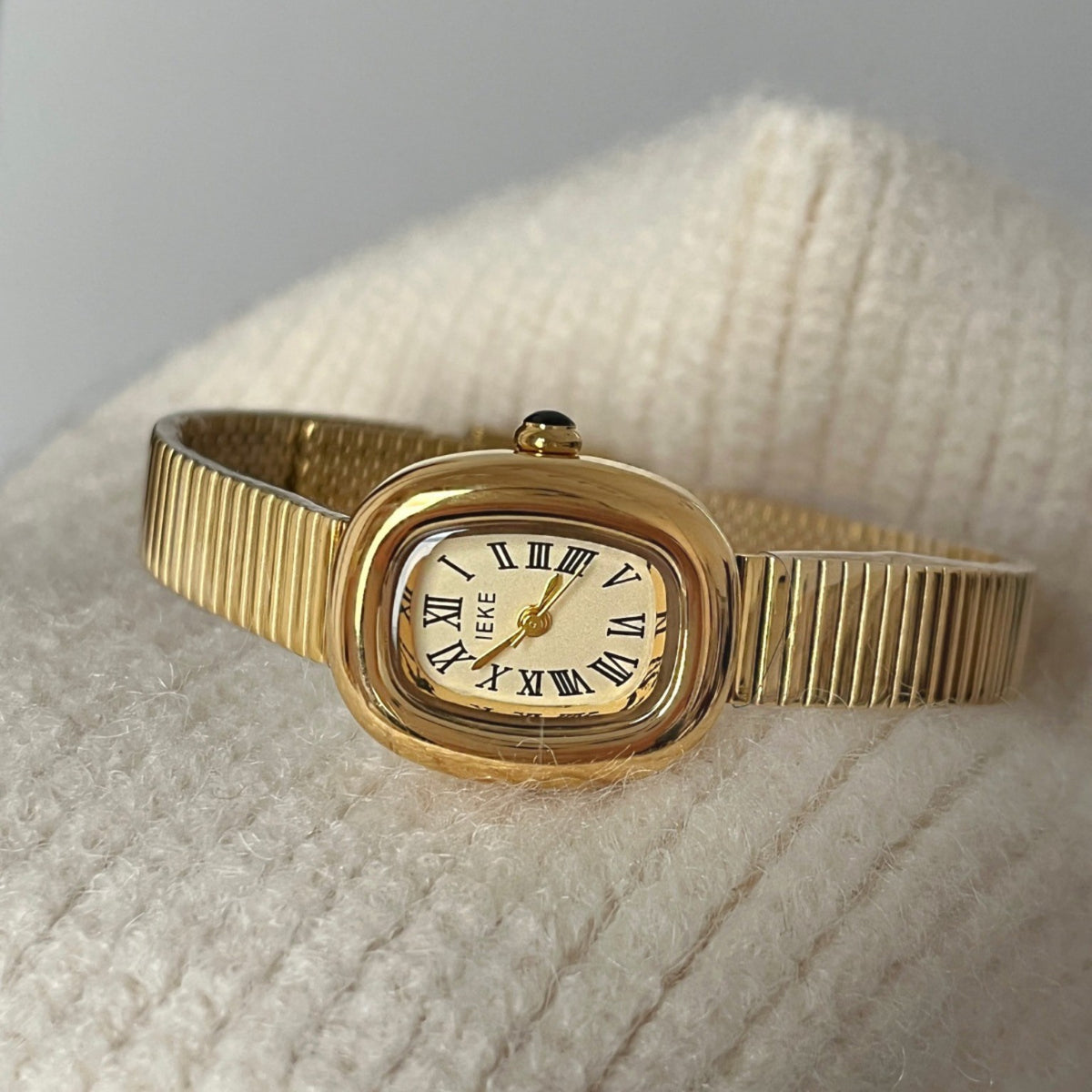 IEKE small women's quartz watch with gold-tone oval case, Roman numeral dial and stretch expansion bracelet