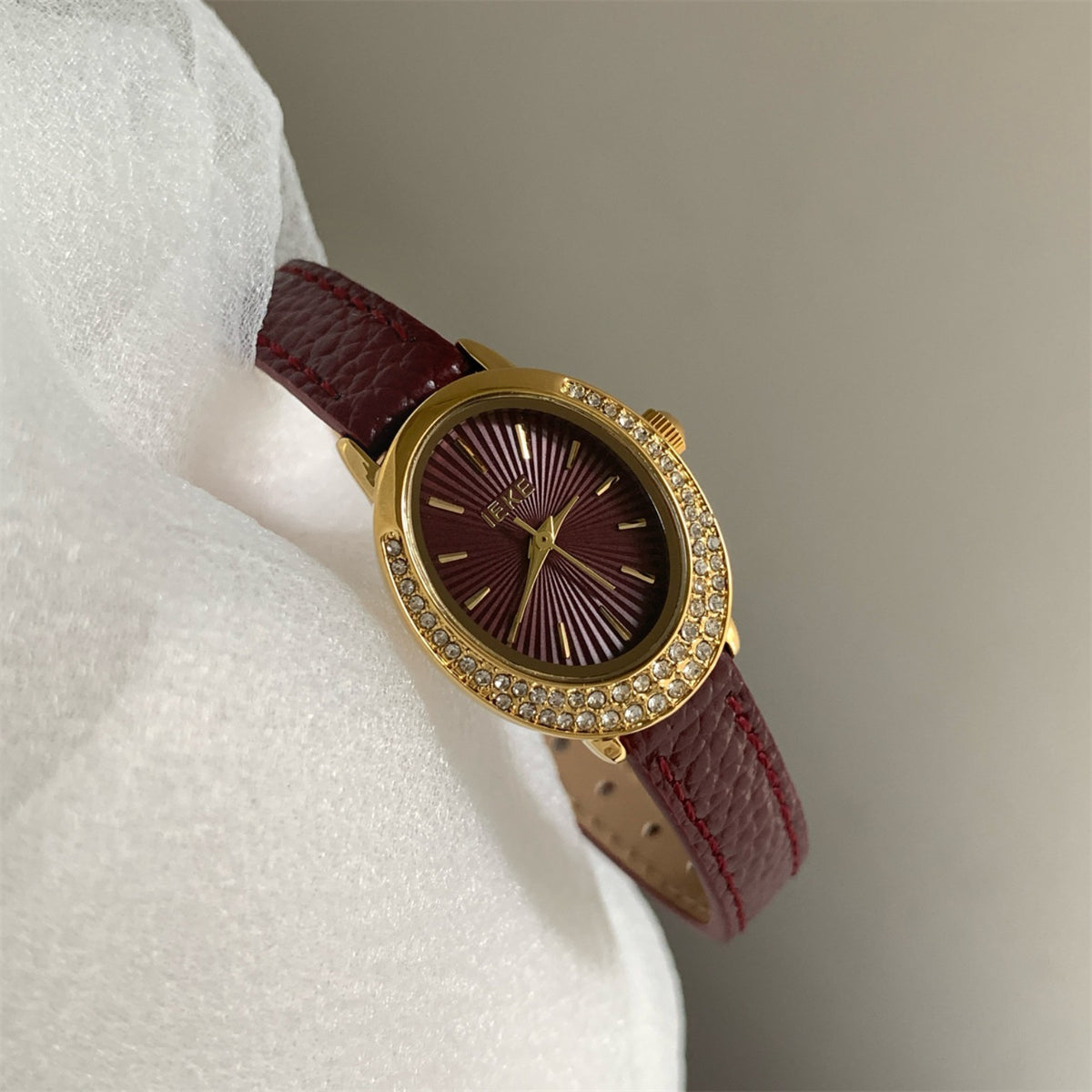 IEKE women's oval crystal watch with wine red strap, gold case and red dial