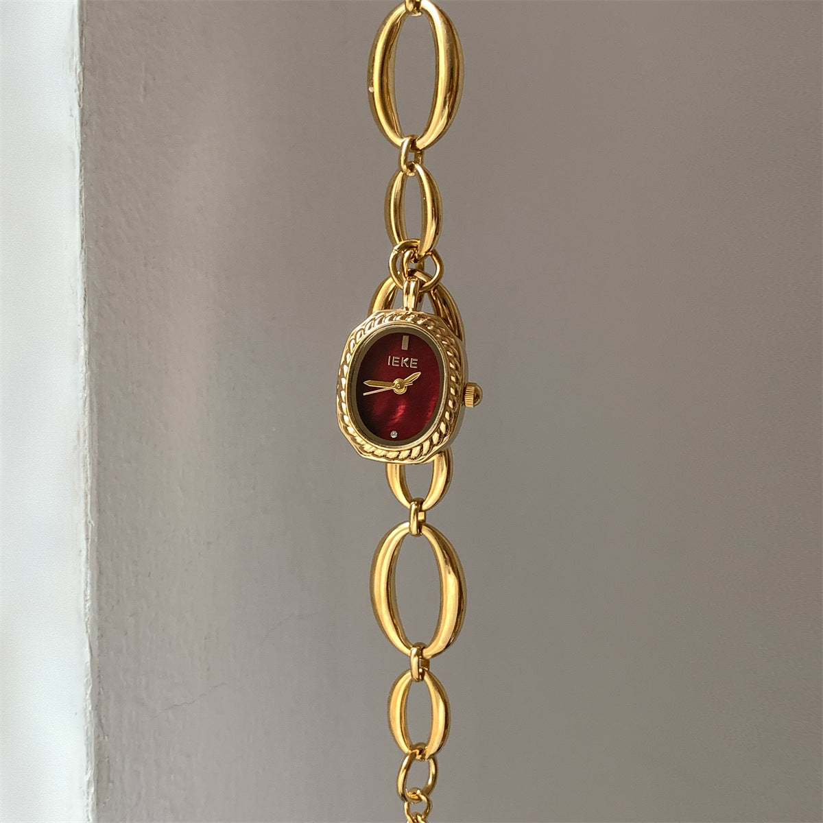 IEKE gold-tone oval-link bracelet watch with burgundy dial