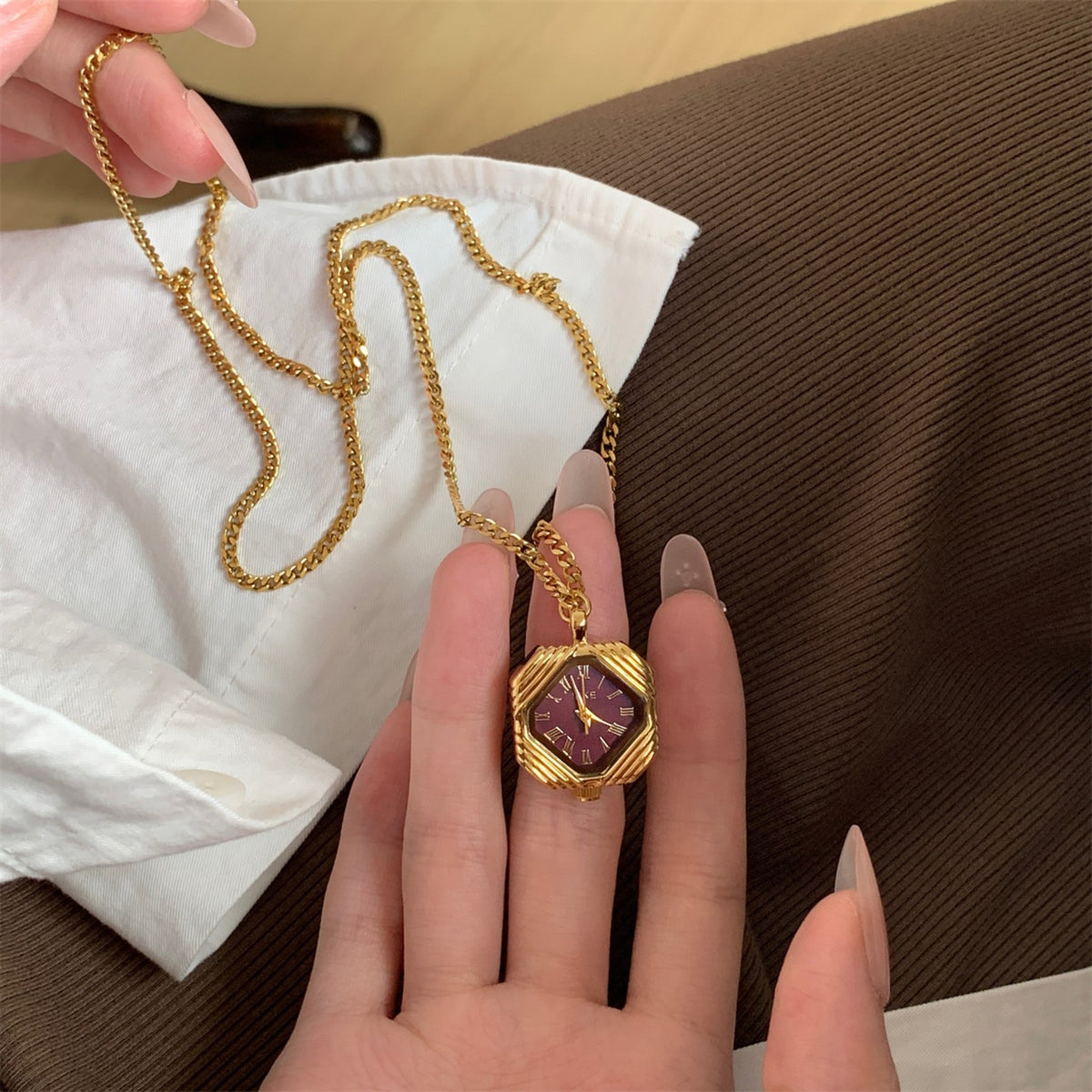 IEKE gold pendant necklace watch with burgundy octagonal dial in hand