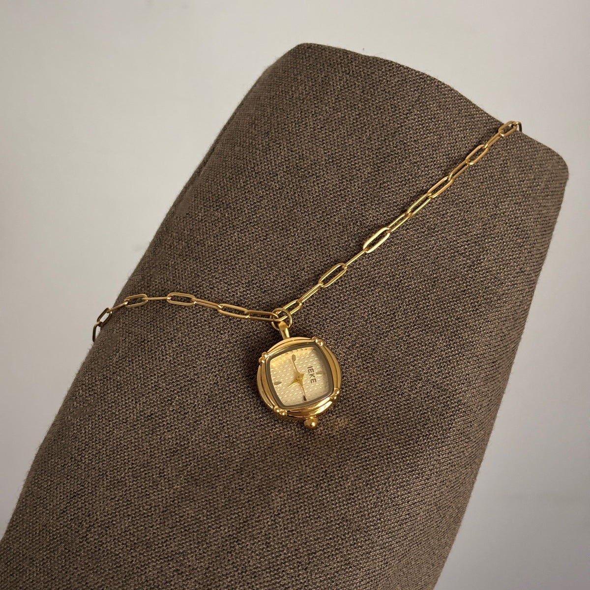 IEKE gold-tone pendant watch with light dial