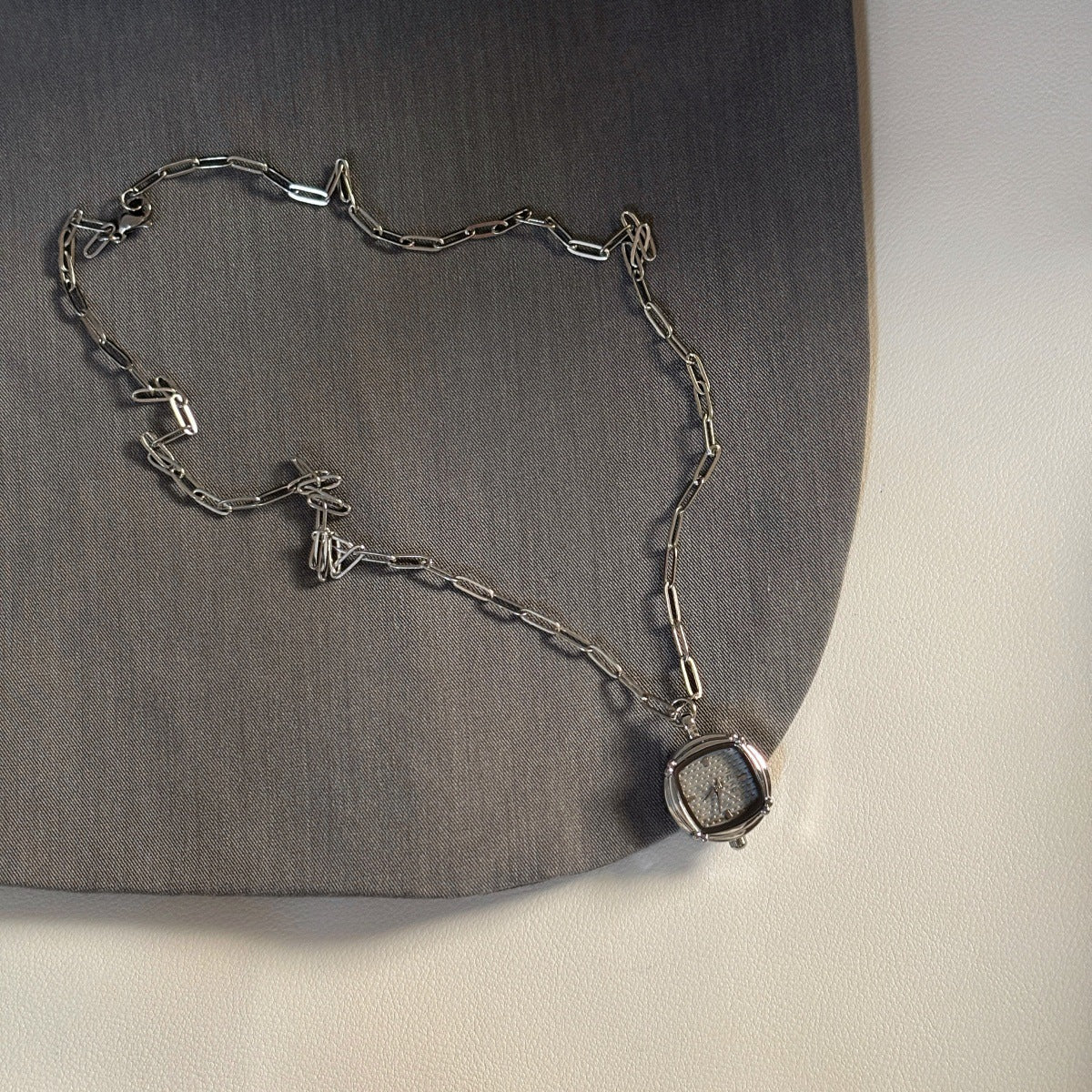 IEKE silver-tone pendant watch with light dial