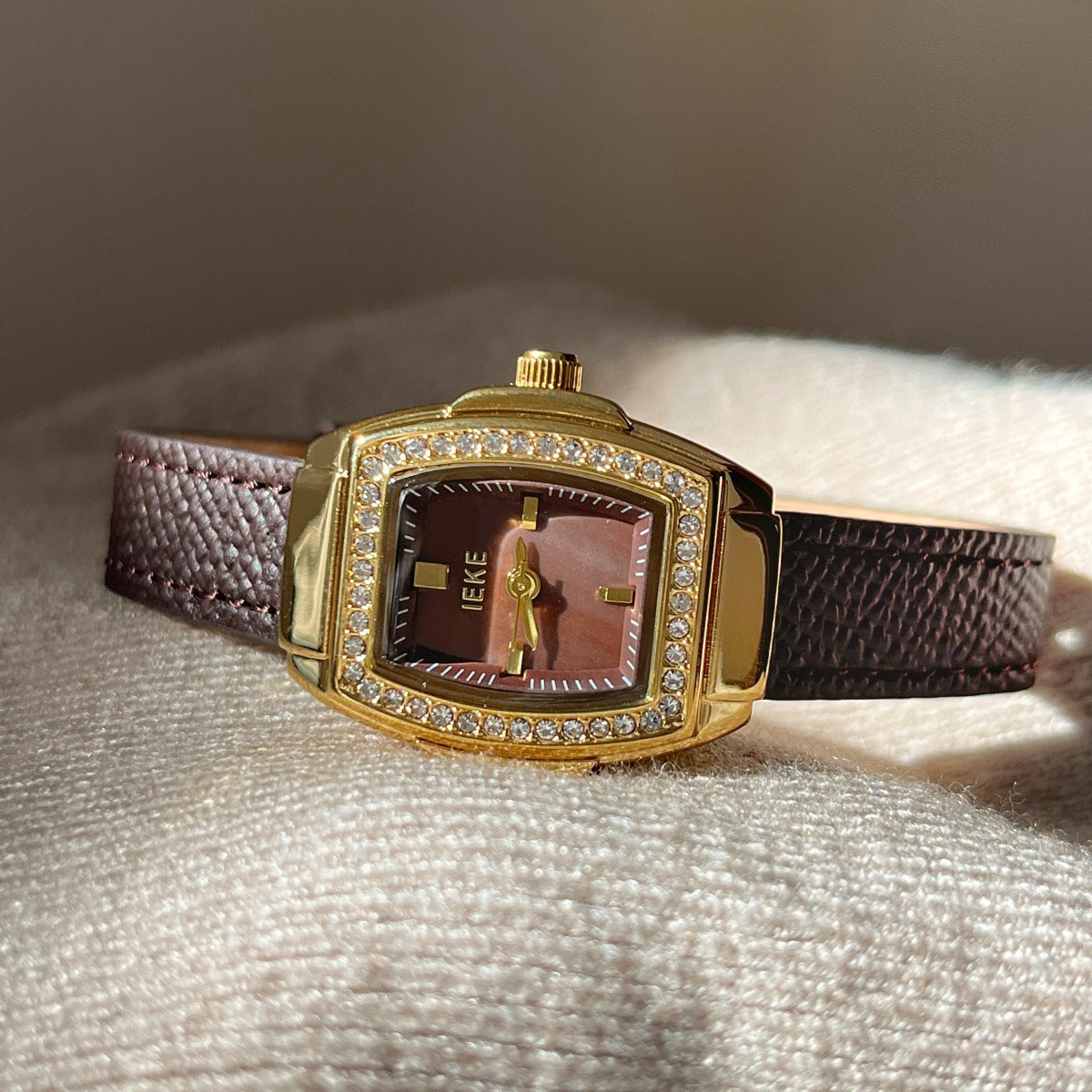 IEKE petite crystal tonneau watch with brown leather-look strap, gold-tone case and brown dial