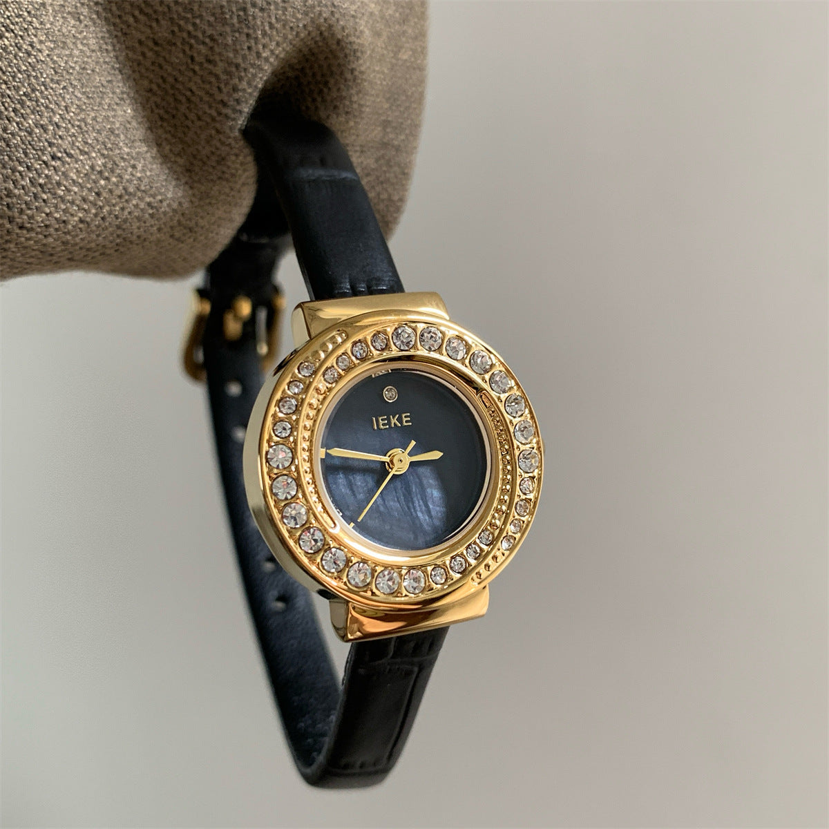 IEKE petite round crystal watch with black strap, gold-tone case and black dial