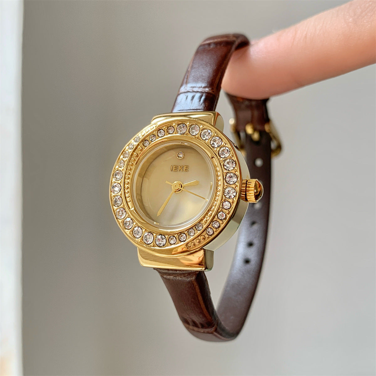 IEKE petite round crystal watch with brown strap, gold-tone case and champagne dial