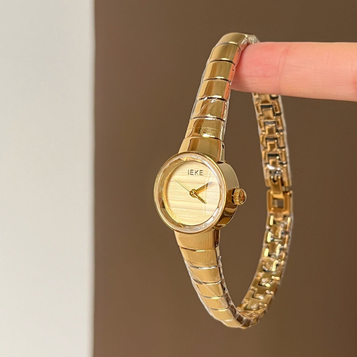 IEKE women's petite round gold-tone quartz watch with champagne dial and polished expansion bracelet