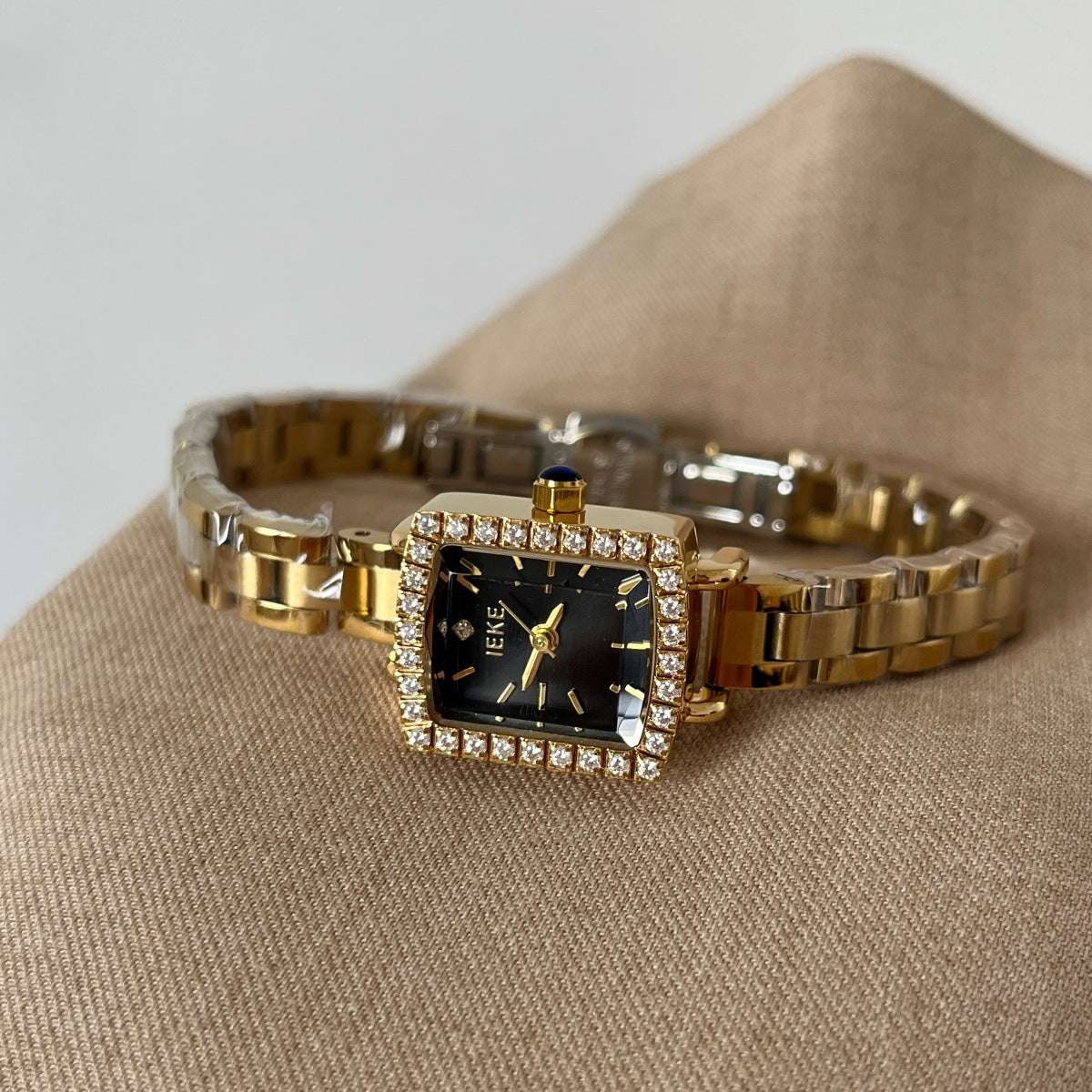 IEKE petite square crystal bezel watch with gold-tone bracelet and black dial