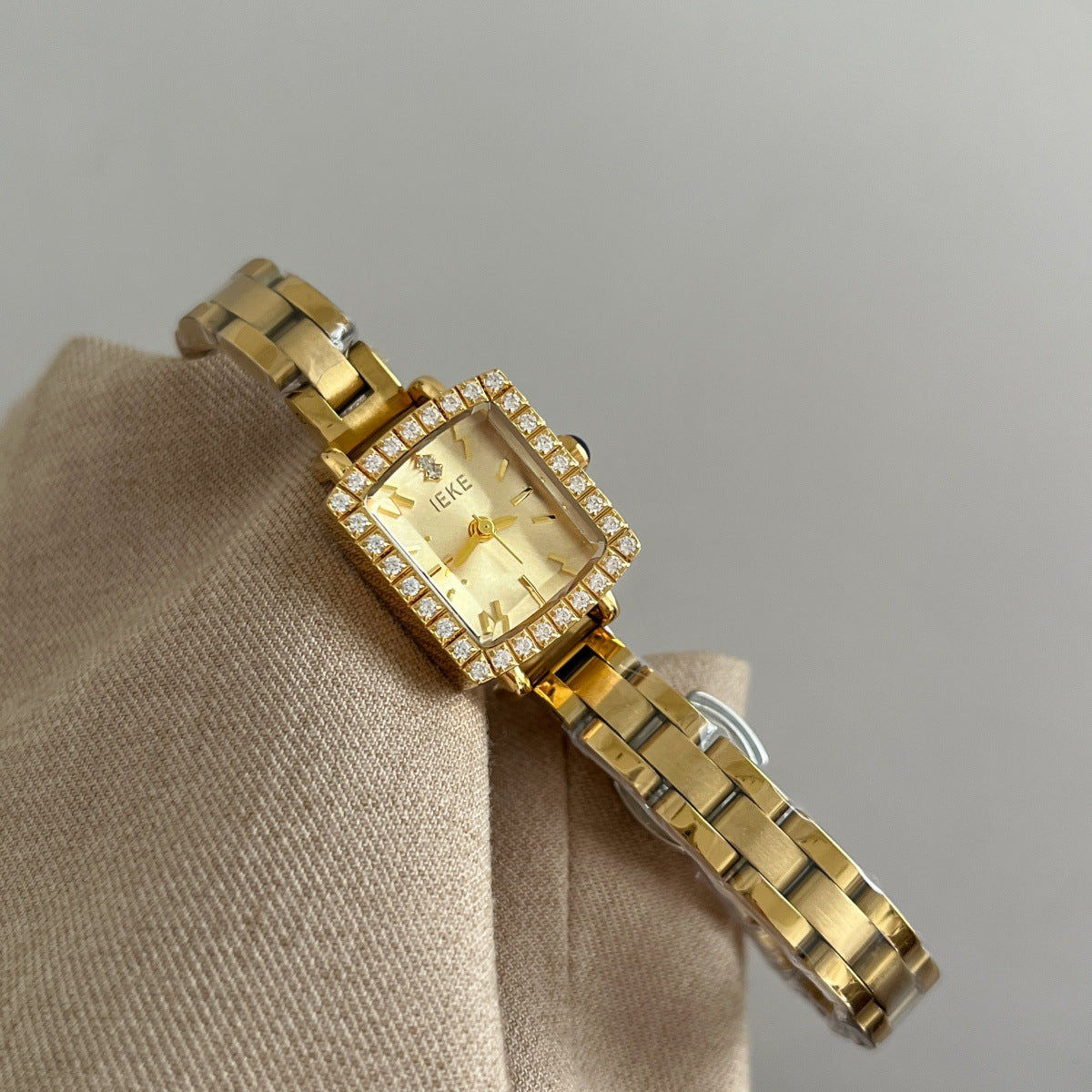 IEKE petite square crystal bezel watch with gold-tone bracelet and champagne dial