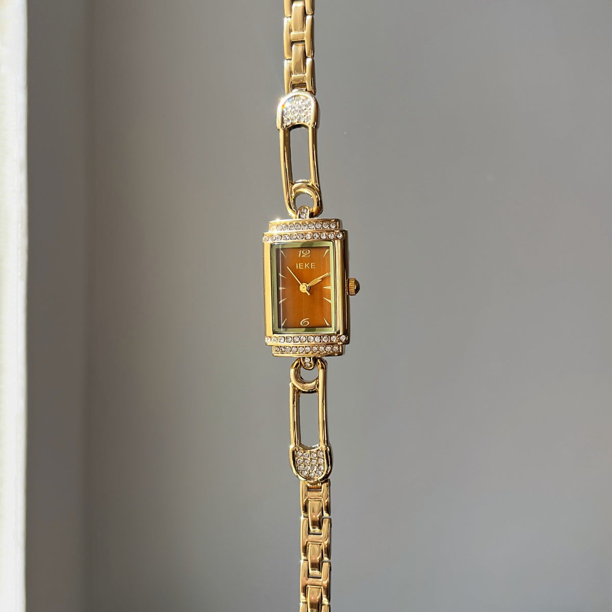 IEKE gold-tone pin-link bracelet watch with amber dial