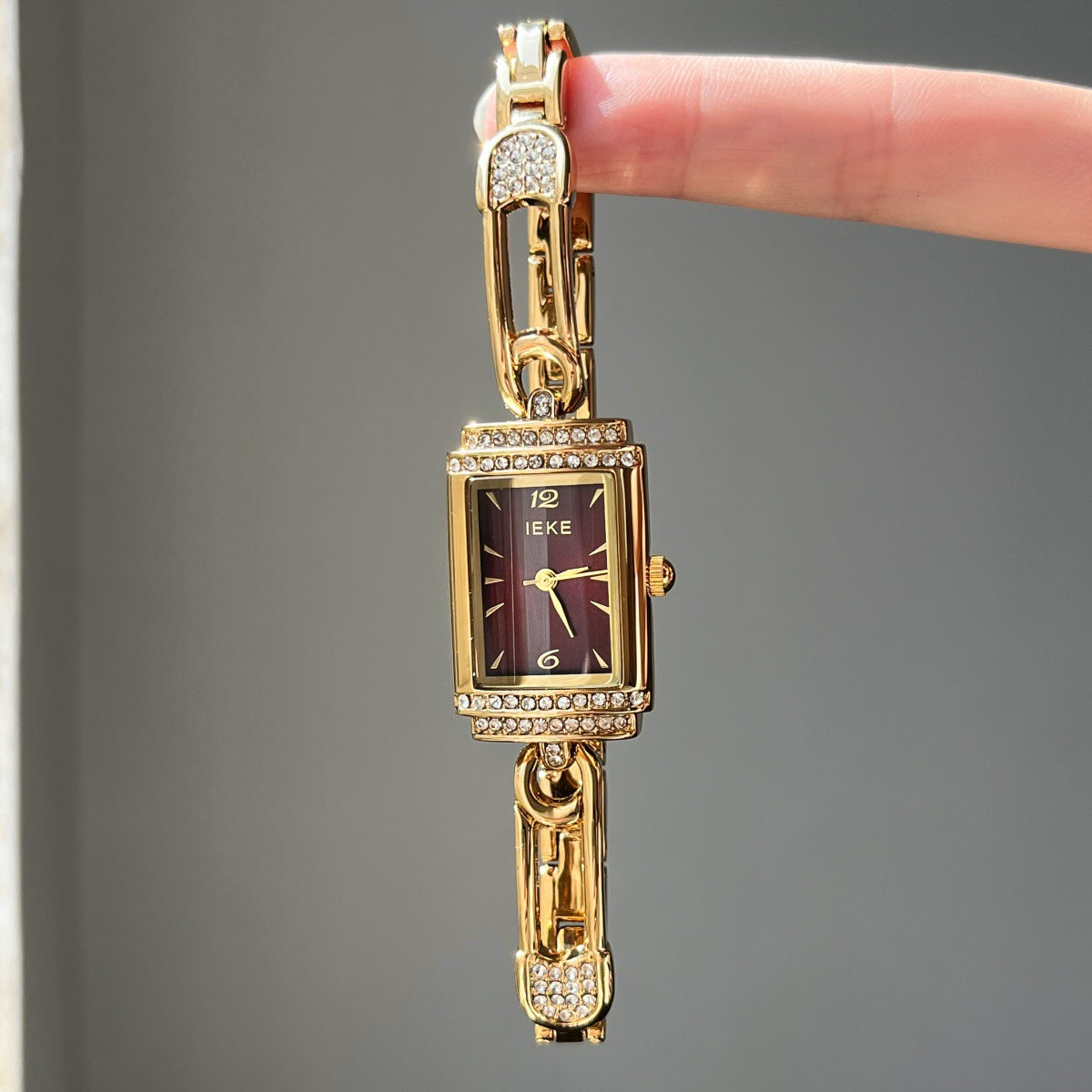 IEKE gold-tone pin-link bracelet watch with burgundy dial