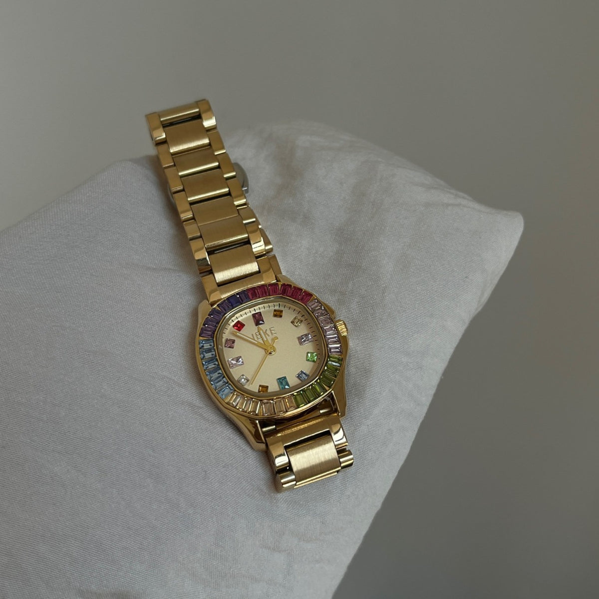 IEKE women's rainbow crystal bracelet watch with gold-tone bracelet and white dial on cushion