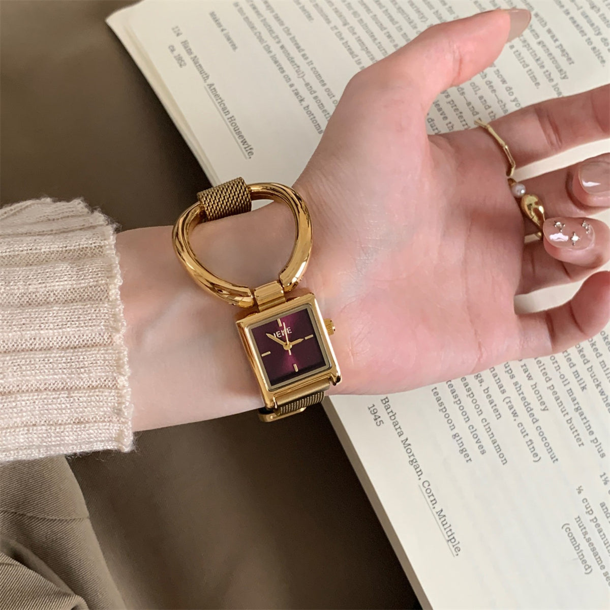 IEKE gold square quartz watch with burgundy dial and oversized ring detail