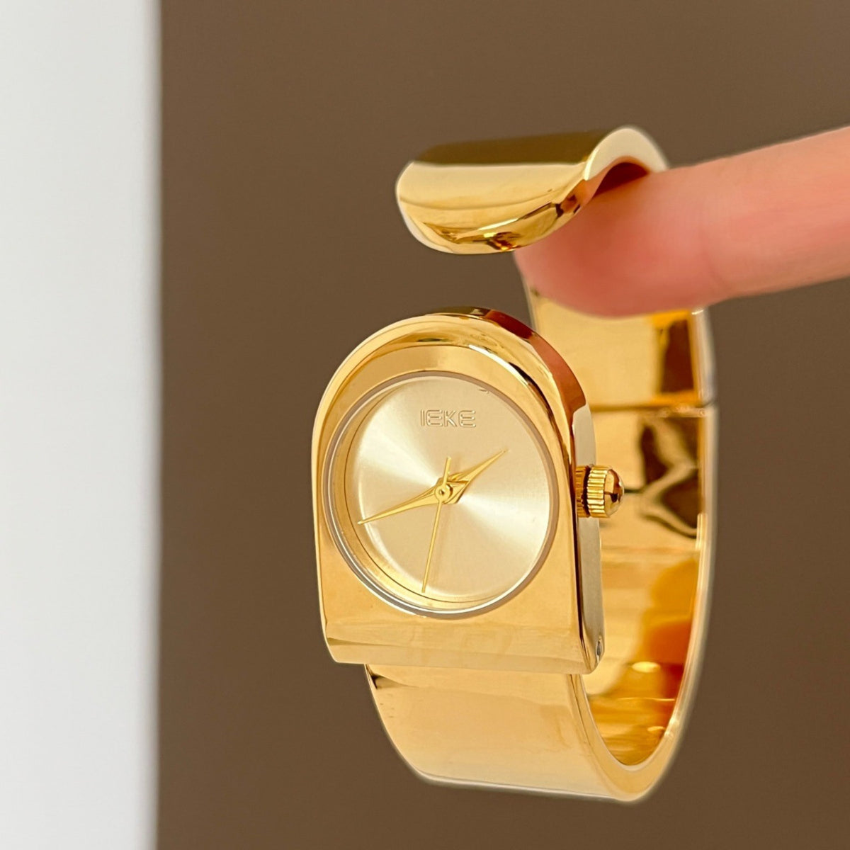 IEKE sculptural cuff bracelet watch in polished gold with gold dial