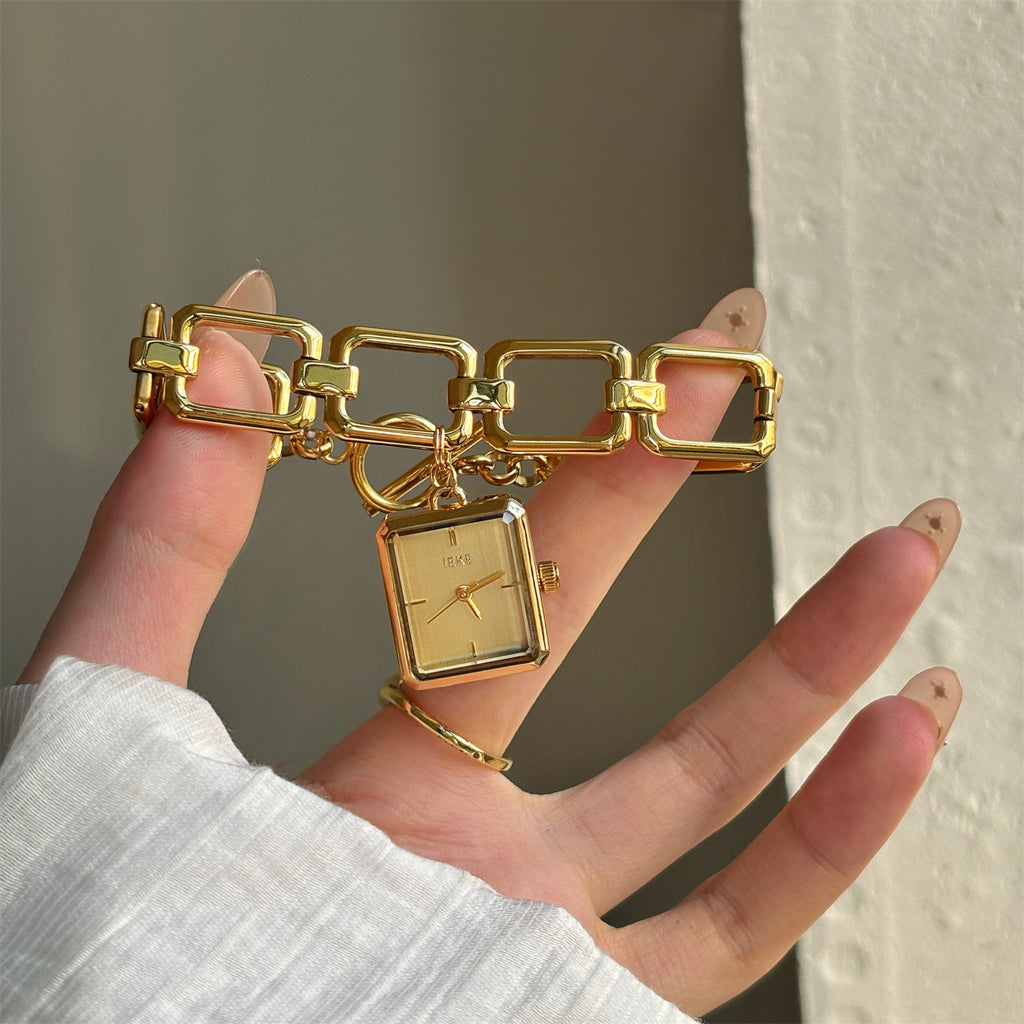 IEKE vintage charm bracelet watch with white dial shown in hand