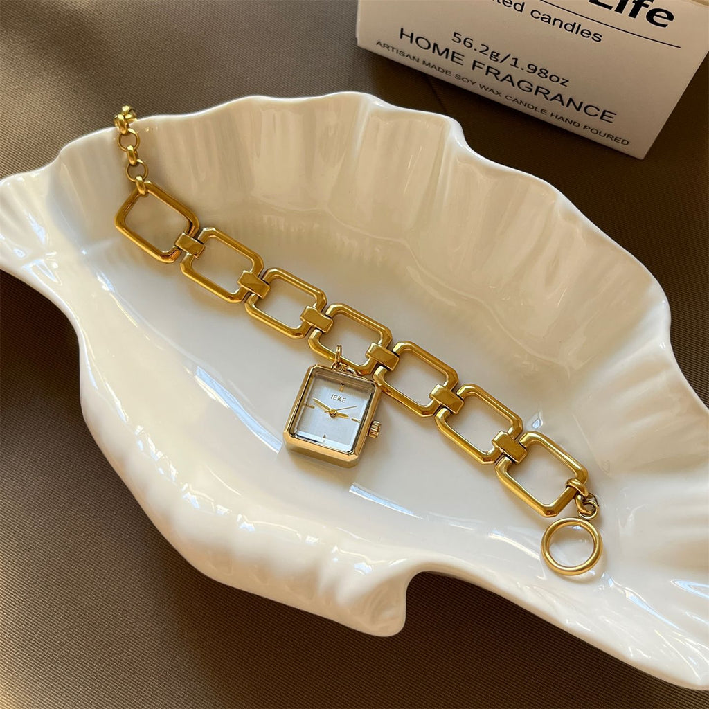 IEKE vintage charm bracelet watch with white dial styled on a shell-shaped dish