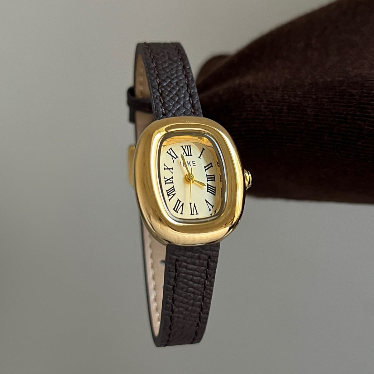 IEKE women's vintage oval quartz watch with cream Roman numeral dial, dark brown leather-style strap and gold-tone case