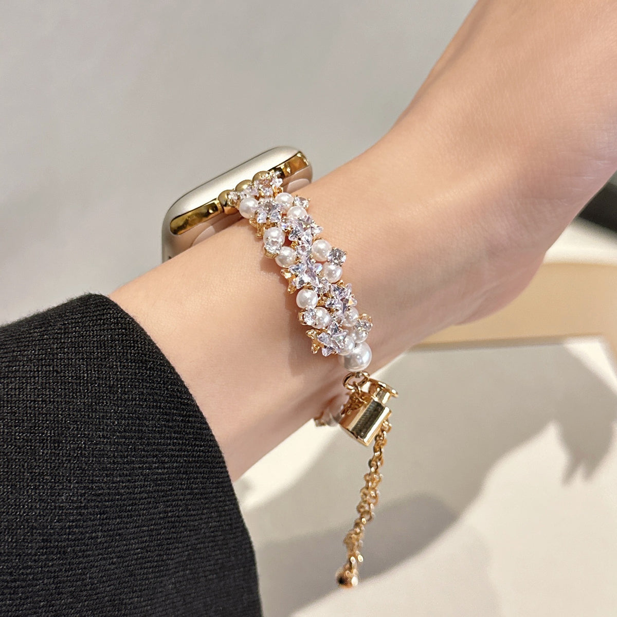 Gold tone pearl and crystal Apple Watch bracelet band worn on wrist