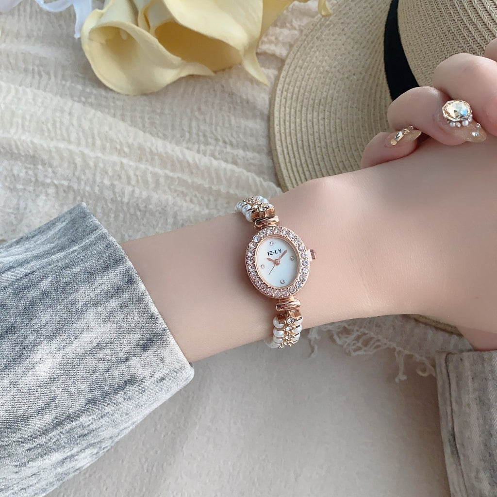 ISLY pearl crystal-style oval bracelet watch in rose gold tone worn on wrist