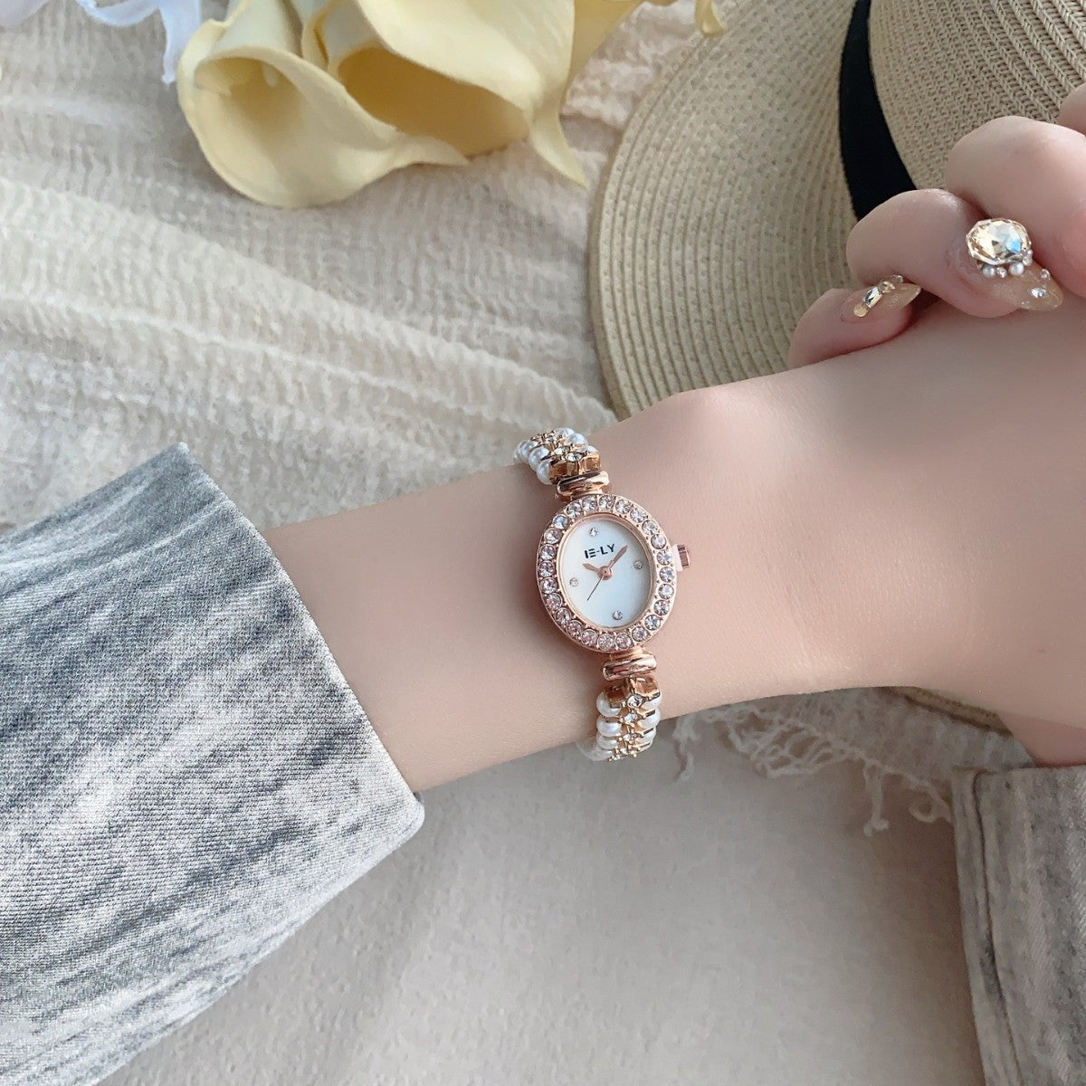 ISLY pearl crystal-style oval bracelet watch in rose gold tone worn on wrist
